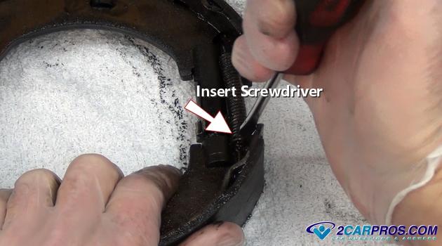 insert screwdriver into spring